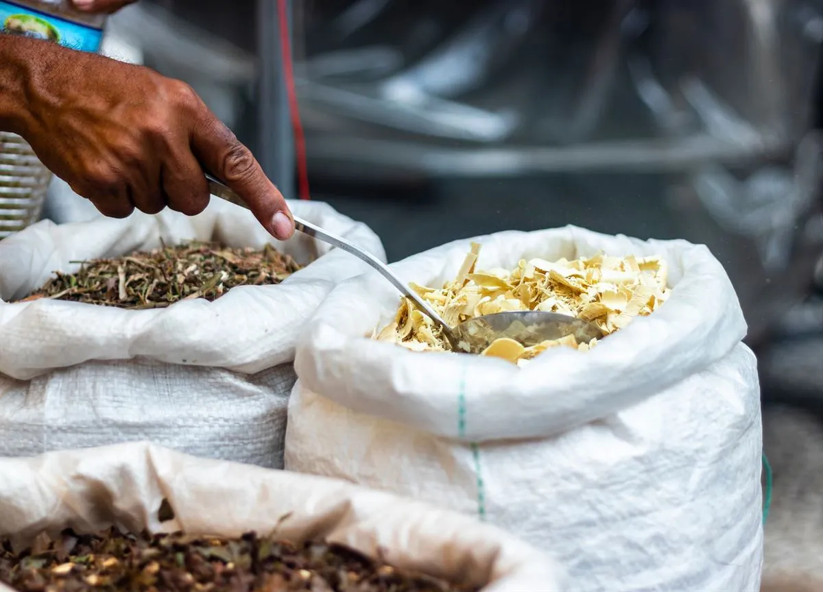 Hand scooping spices from open sacks